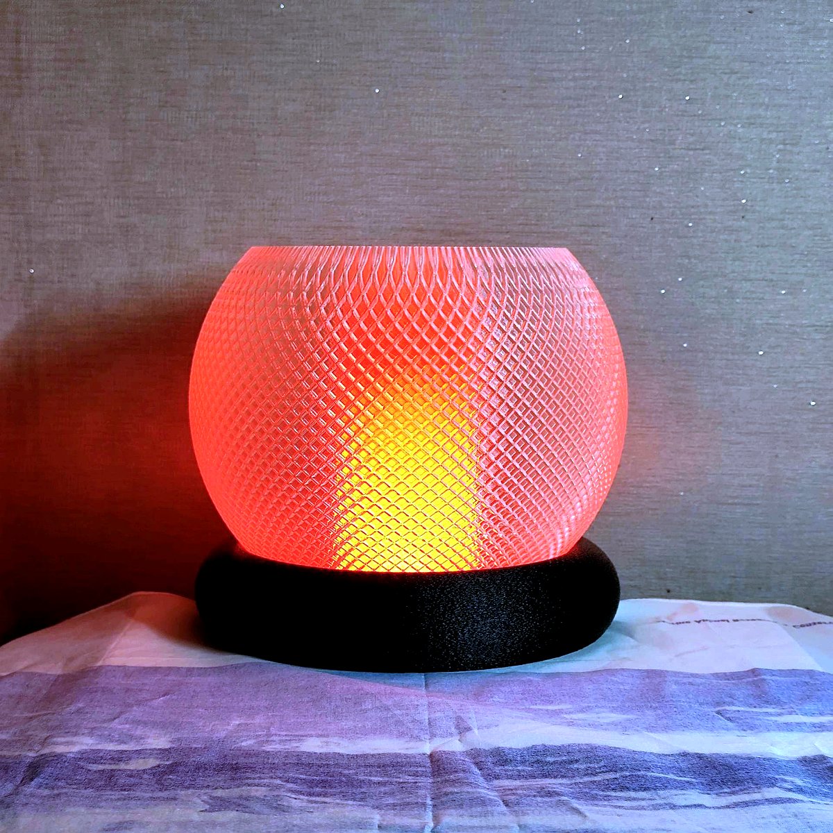 Hero shot of modern intricate 3D printed Diwali lamps casting kaleidoscopic geometric light patterns on dark textured surface. Glowing warmly from inside with golden amber light, framed by neon cyan teal and purple ambient rim lighting. Dark studio photography, high precision 3D printing layers visible, festive modern aesthetic.